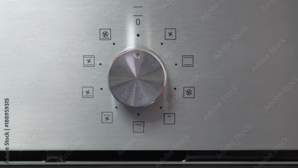 Metallic Toggle Switch of the Cooker Oven. Close-up View. Digital Clock of oven. Front panel of modern metalic oven, red indicators, new shiny buttons. Modern design in details. Household appliances. Metallic Toggle Switch of the Cooker Oven. Close-up View. Digital Clock of oven. Front panel of modern metalic oven, red indicators, new shiny buttons. Modern design in details. Household appliances.