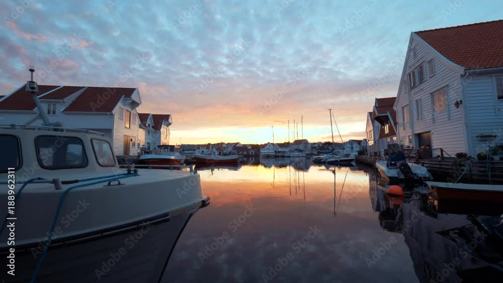 Amazing embankment and seaport. Water transport, yachts, ships, boats, white great private houses on the seashore. Typical European seascape. Beautiful nature at sunset. Red and yellow sky at sunrise