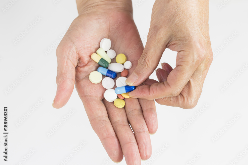 Senior woman holding assorted capsules in her hands. Conceptual of health care for the elderly. Senior woman holding assorted capsules in her hands. Conceptual of health care for the elderly.