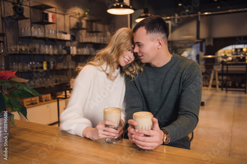 A couple is sitting in the cafe and celebrating Valentine's day. They are on a date. The atmosphere of love in the air.