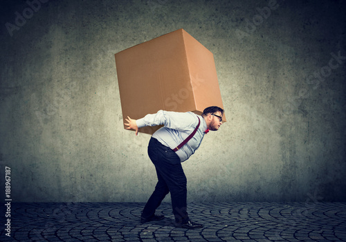 Man carrying heavy box on back