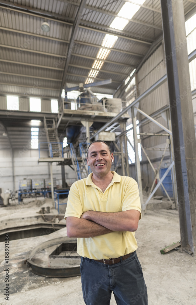 Boss posing in concrete factory with portable headphoe on ears Boss posing in concrete factory with portable headphoe on ears