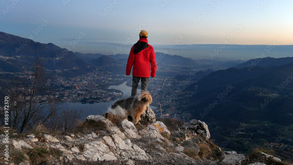 Uomo con il cane osserva il panorama la sera