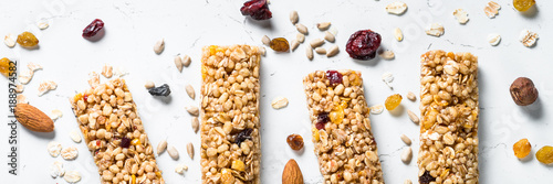 Fototapeta Granola bar with nuts, fruit and berries on white.