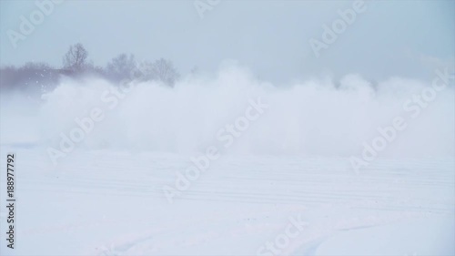 Snowy road in forest with car by and making a 180 turn slow motion . Car is making a drift in the snow. Car rides on a snowy road in winter time photo