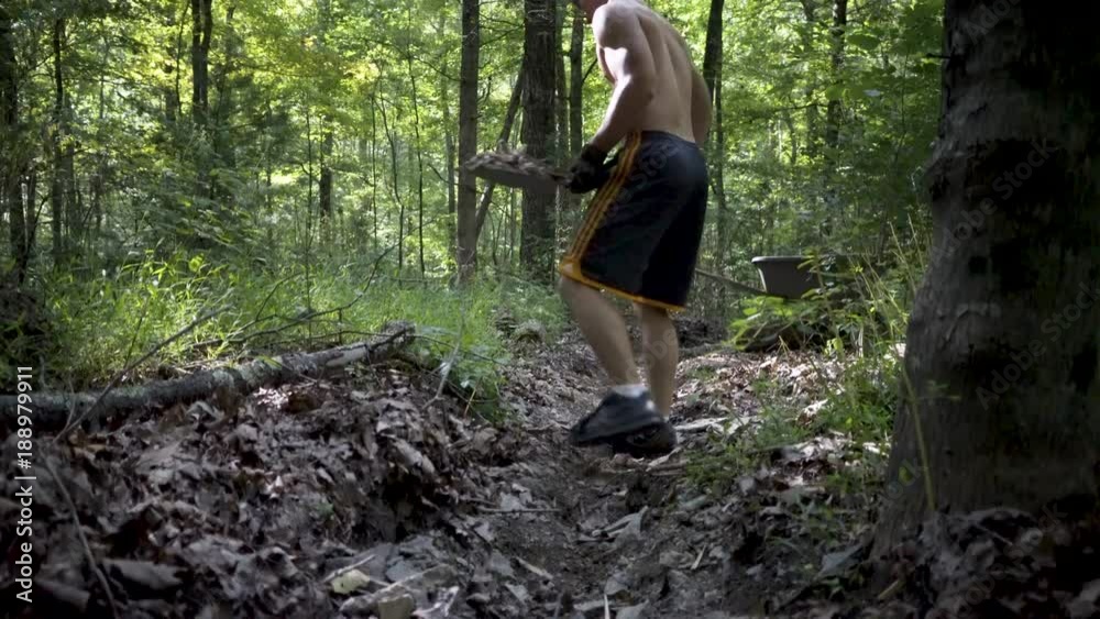 Closeup on digging dirt and rocks as a young muscular shirtless man digs and puts it into a wheelbarrow. Closeup on digging dirt and rocks as a young muscular shirtless man digs and puts it into a wheelbarrow.