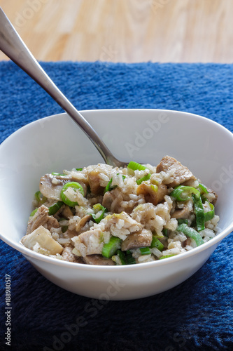 Pork and mushroom Stroganoff with rice on a blue background vertical view