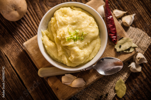 mash potatos in a white porcelain bowl on wood table  photo