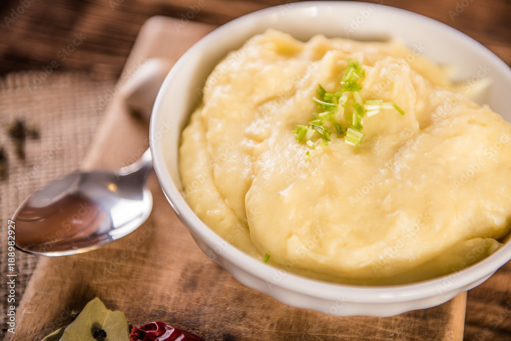 mash potatos in a white porcelain bowl on wood table 