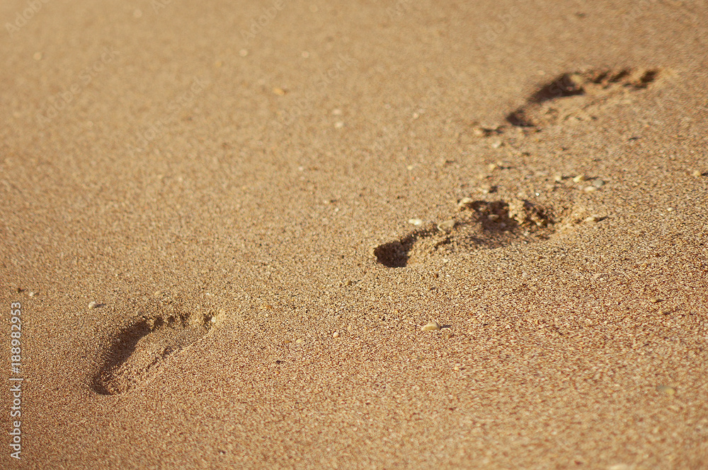 Footprint or trace in summer sand beach or coastline on holidays - background texture - top view