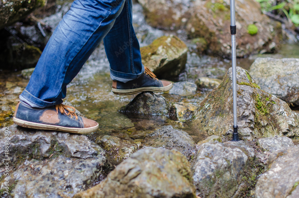 Adult's feet walk along the mountain path Adult's feet walk along the mountain path