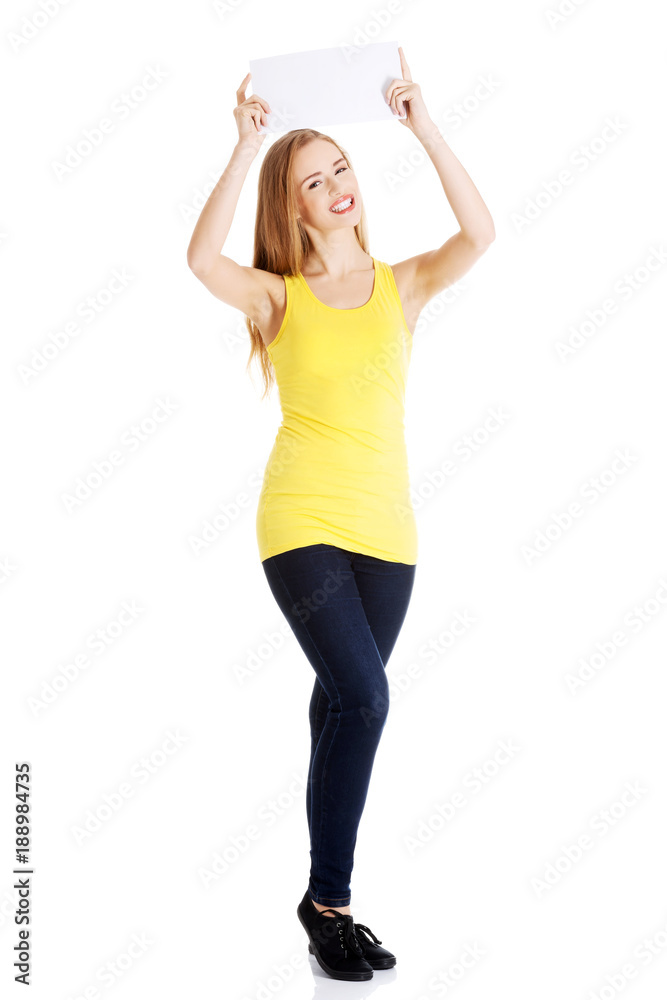 Attractive casual caucasian woman holds empty white piece of paper. Attractive casual caucasian woman holds empty white piece of paper.