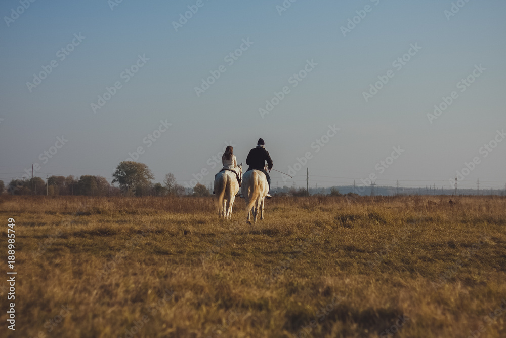 Obraz premium Two people on horseback in the field