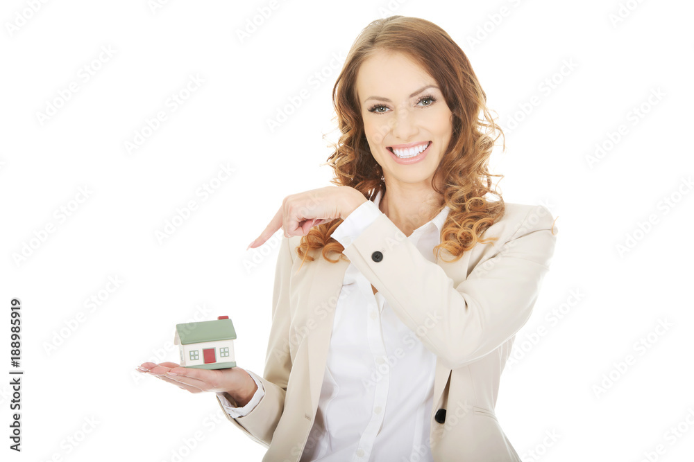 Businesswoman pointing on a model house. Businesswoman pointing on a model house.