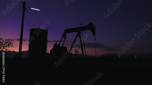 Silhouette Moving Crude Oil And Petrochemical Products Pumping Stations During Sunset Time. Land oilfield in the Northern of Thailand. photo