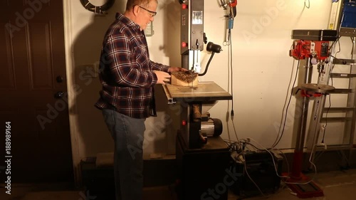 Man using a wood-cutting bandsaw to shape a circle for turning a bowl photo