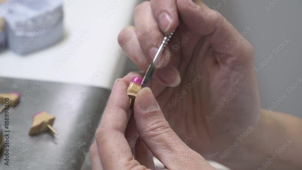 Dental technician working with tooth dentures at prosthesis laboratory