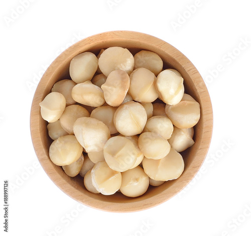 Macadamia nut in wooden bowl isolated on white background