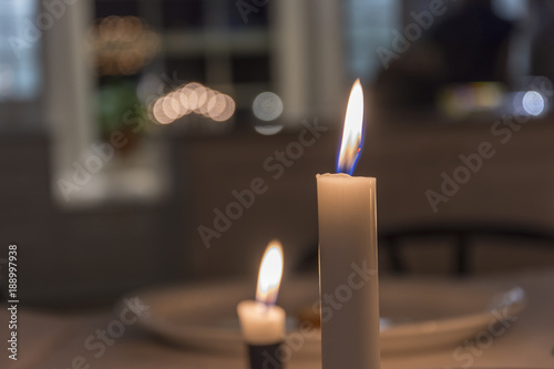 Obraz na plátně Rund julljusstake lyser med sina fyra tända ljus på julbordet