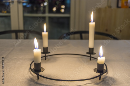 Cuadro en lienzo Rund julljusstake lyser med sina fyra tända ljus på julbordet