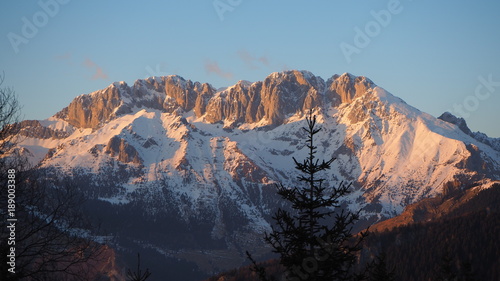 Presolana is a mountain range of the Orobie  Italian Alps. Landscape in winter. At sunset the rocks become red  orange and pink