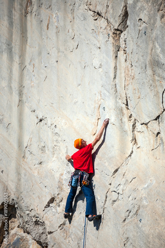 A man is training to climb on a rock.