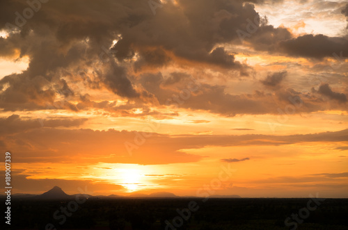 Sunset / sunrise with vivid magenta sky, clouds and mountains dark silhouettes