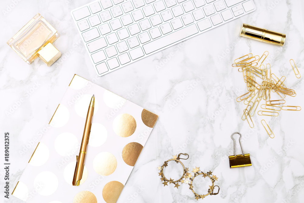 Φωτογραφία Keyboard c of office items of gold color and cosmetics on the desktop of the house