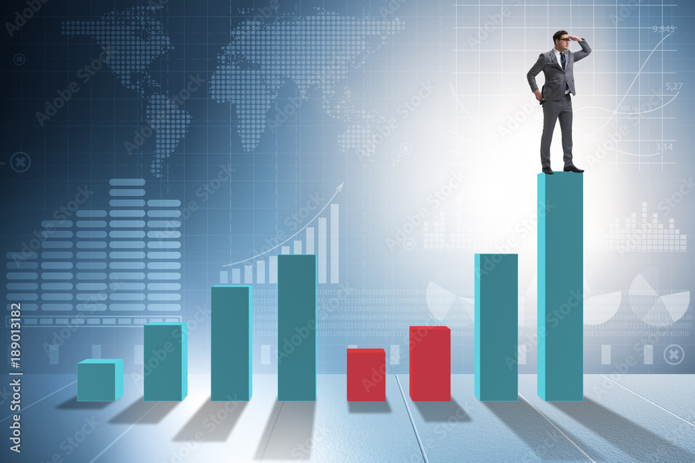 Young businessman in business concept with bar charts Young businessman in business concept with bar charts