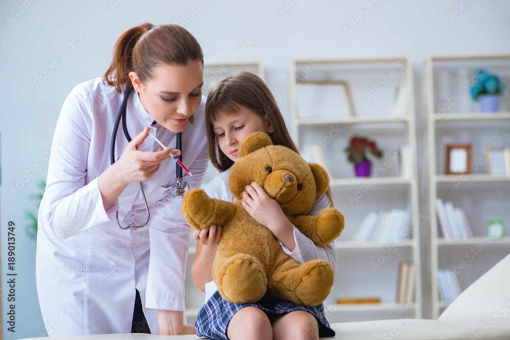 Woman female doctor examining little cute girl with toy bear Woman female doctor examining little cute girl with toy bear