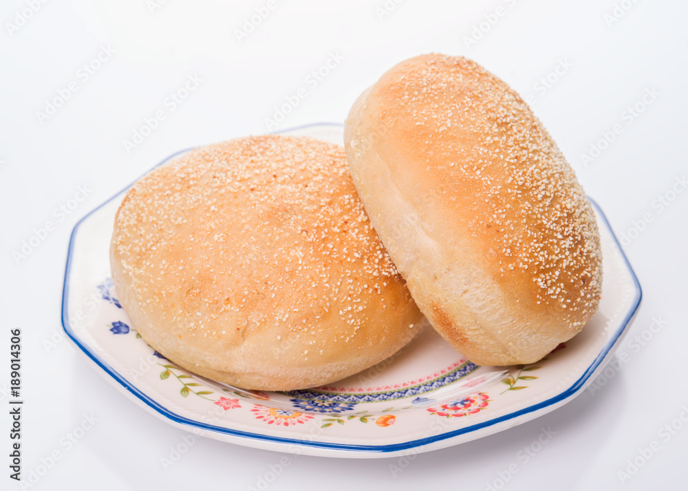 Sesame bread buns in earthenware dish, isolated on white background Sesame bread buns in earthenware dish, isolated on white background