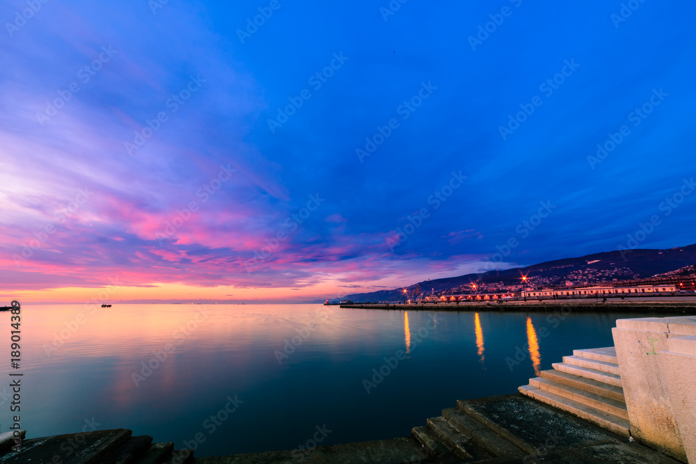Colorful sunset in front of the city of Trieste