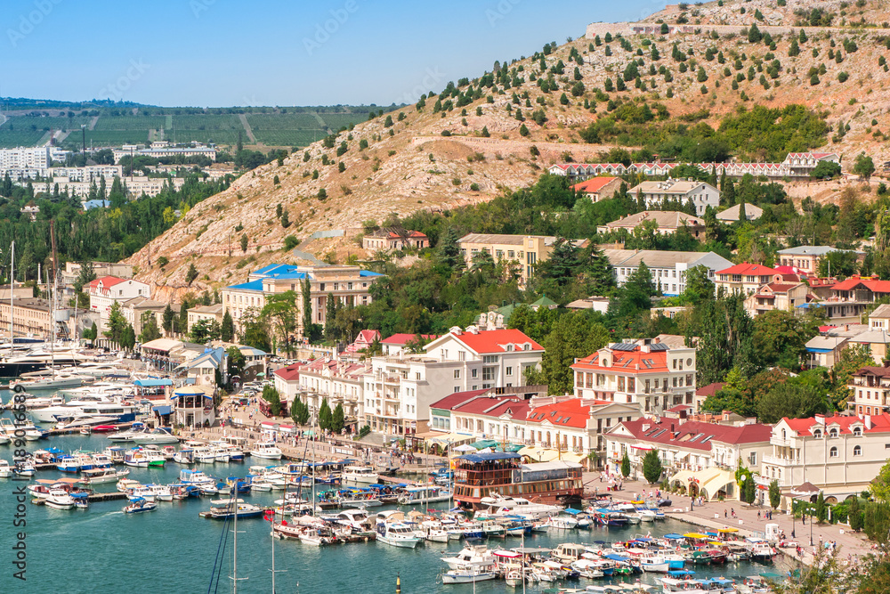 Aerial view of Old Town port, sea and mountains. Yachts and boats moored at the pier. Balaklava, Sevastopol, Crimea