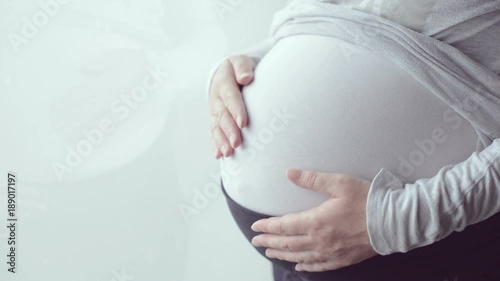 Pregnant woman tummy, female person in ninth month of pregnancy posing