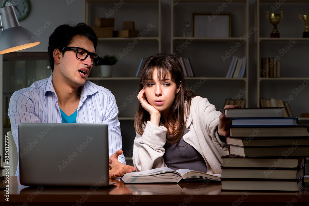 Two students studying late preparing for exams Two students studying late preparing for exams