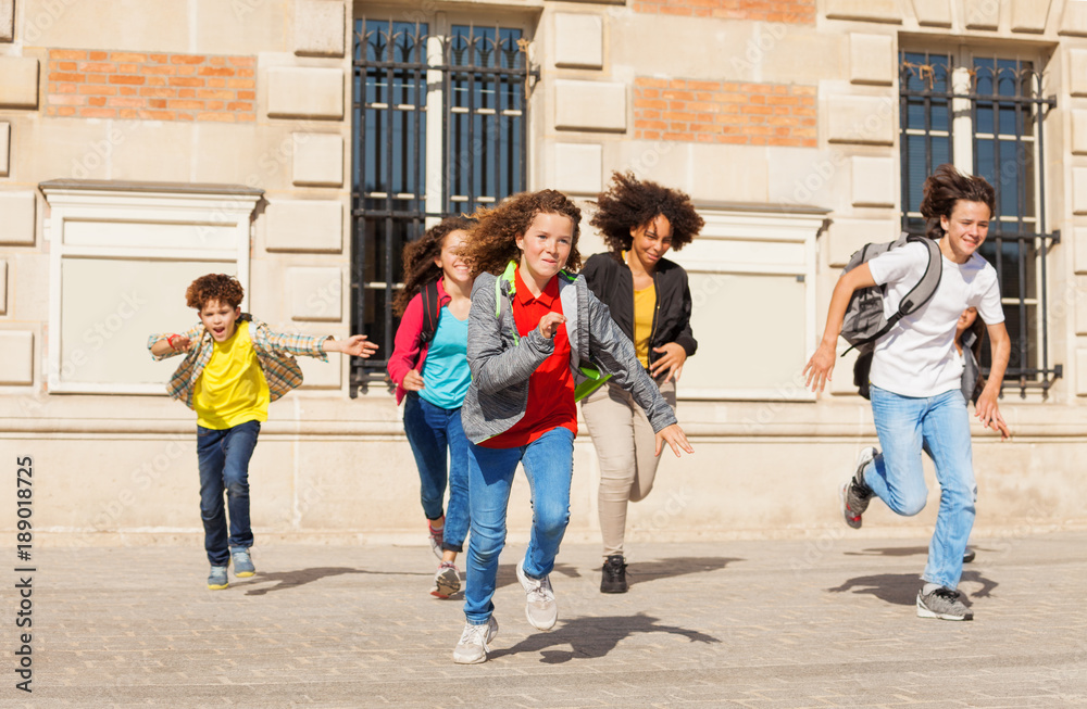 Obraz premium Cute pupils running from school building