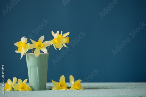 Fototapeta Naklejka Na Ścianę i Meble -  daffodils in vase on blue background