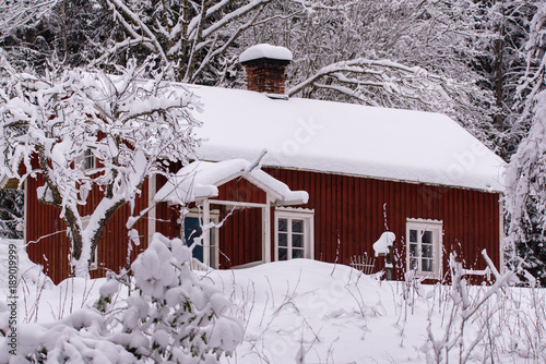 red wooden house in a snowy and cold varmland sweden