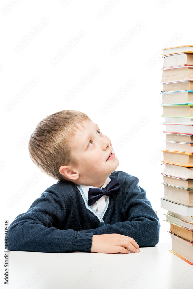 the schoolboy looks at the heap of books on the table the schoolboy looks at the heap of books on the table