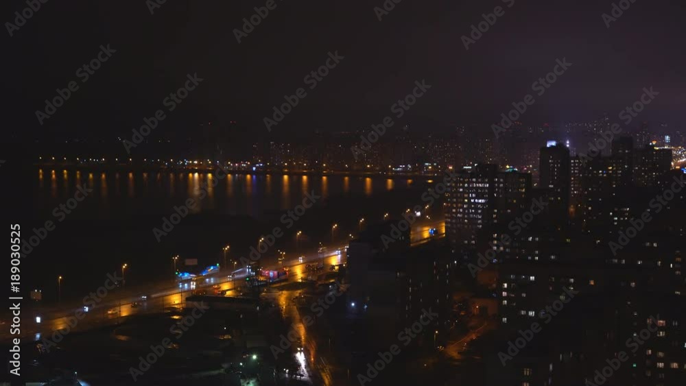 shooting night city. The lights are burning in the windows of apartment buildings. On the asphalt reflections glare from the passing cars. light is splashing in the water. lake or river. 4k shooting night city. The lights are burning in the windows of apartment buildings. On the asphalt reflections glare from the passing cars. light is splashing in the water. lake or river. 4k