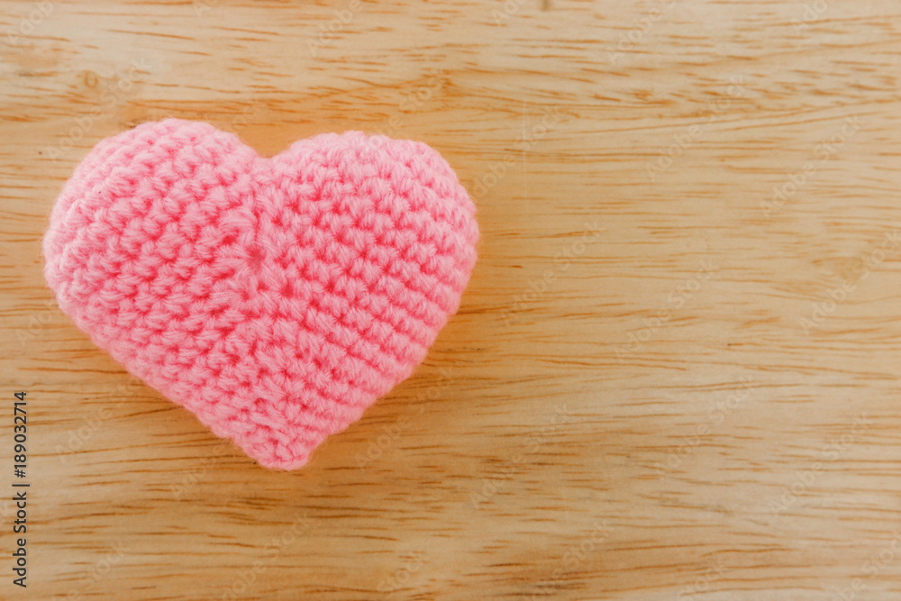 Pink heart knit with yarn on wooden floor. Pink heart knit with yarn on wooden floor.