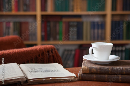 Sweet moments of relaxation with books and a cup of coffee. Vintage books, glasses, chair, library
