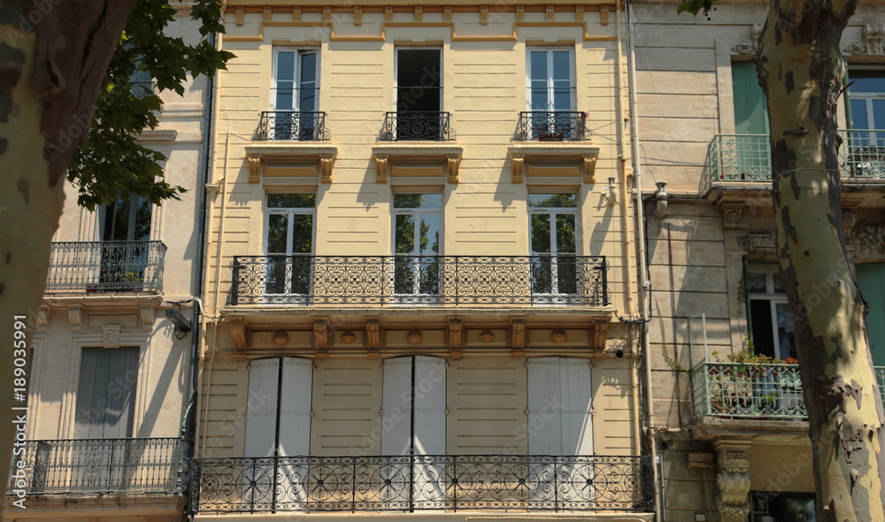 Stylish cross section of apartment balconies, sunny day in a small village square in the South of France Stylish cross section of apartment balconies, sunny day in a small village square in the South of France