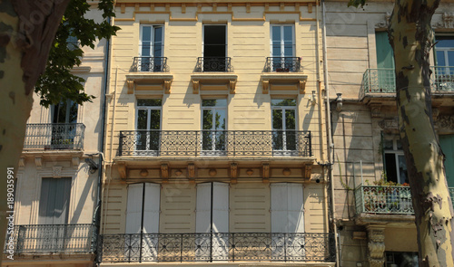 Stylish cross section of apartment balconies, sunny day in a small village square in the South of France