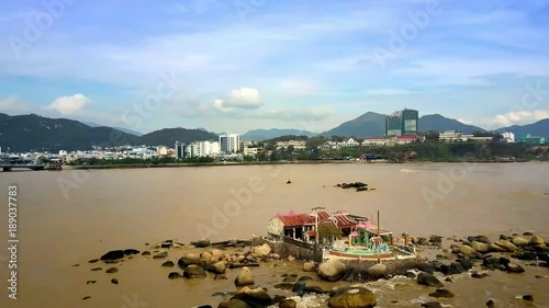 Buddhist Temple on Rocky Island at Sea by Resort City photo