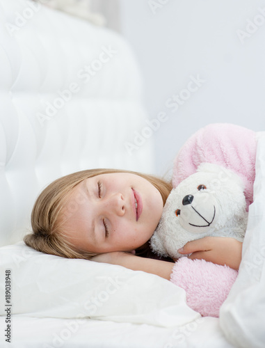 Sleeping girl hugging a toy bear