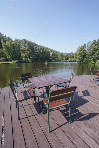 wooden table and chairs of a cafe by lake