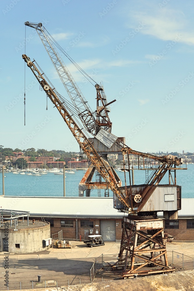 Selective focus of old crane at loading dockyard. Historical structure of old crane with rustic at port.
