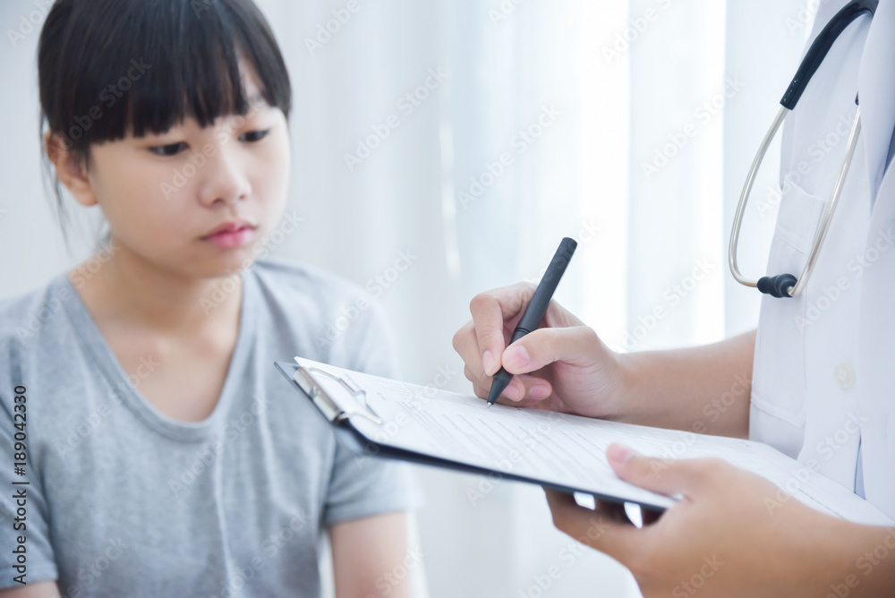 Doctor taking note on checklist for a little girl patients. Doctor taking note on checklist for a little girl patients.