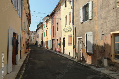 Multi-coloured row of cottages  situated along a deserted village street in the South of France